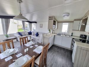 a kitchen and a dining room with a table and a kitchen and a living room at Seven Sunsets, Padstow in Padstow
