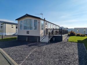 a tiny house with a staircase and a porch at Seven Sunsets, Padstow in Padstow