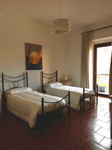 2 Betten in einem Zimmer mit Fenster in der Unterkunft Casa Vacanze Il Geranio in Iglesias