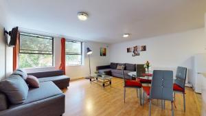 ein Wohnzimmer mit einem Sofa und einem Tisch in der Unterkunft The Queensborough Apartments by Hyde Park in London