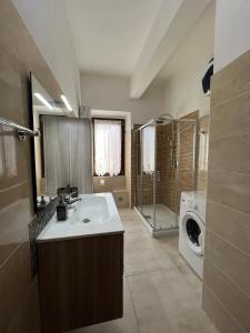 ein Badezimmer mit einem Waschbecken und einer Waschmaschine in der Unterkunft Casa Vacanze Il Geranio in Iglesias