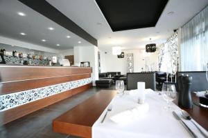 a restaurant with a white table and a bar at Grand hotel/pension in Sládkovičovo