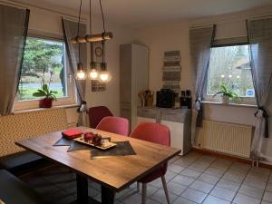 uma sala de jantar com uma mesa de madeira e cadeiras vermelhas em Ferienhaus Sternenhimmel em Thalfang