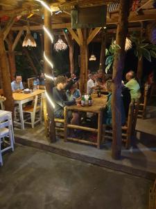 a group of people sitting at tables in a restaurant at Tetebatu Sama Sama Bungalows in Tetebatu