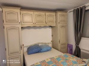 a bedroom with a bed with blue pillows on it at Maison avec deux chambres au calme in Milly-la-Forêt