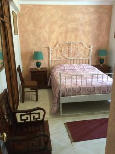 a bedroom with a bed and two lamps and a chair at Vintage apartment Milfontes in Vila Nova de Milfontes