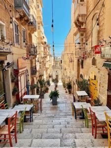 an alley with tables and chairs in a city at Flat in Valletta in Valletta