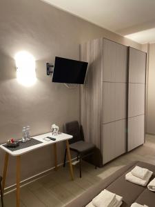 um quarto com uma secretária e um armário com uma televisão em Rosy Bed&Breakfast em Terni