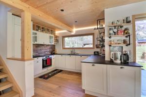 cocina con armarios blancos y techo de madera en B&B Bagnes, en Versegeres 