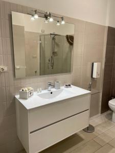 uma casa de banho com um lavatório, um espelho e um WC. em Rosy Bed&Breakfast em Terni