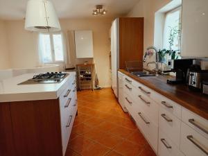 a kitchen with white cabinets and a stove top oven at Villa avec piscine aux pieds des collines de Marcel Pagnol in Allauch