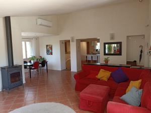 ein Wohnzimmer mit einem roten Sofa und einem Kamin in der Unterkunft Villa avec piscine aux pieds des collines de Marcel Pagnol in Allauch