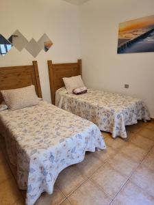 カレタ・デ・ファマラにあるFamara Velaのベッド2台が隣同士に設置された部屋です。