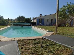 einen Pool mit einem Tisch im Hof in der Unterkunft Villa avec piscine aux pieds des collines de Marcel Pagnol in Allauch