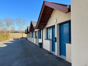 een rij gebouwen met blauwe deuren erop bij Hôtel Le Laury's in Onet le Château