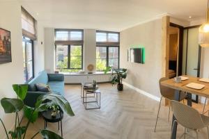 a living room with a blue couch and a table at Alkmaar center apartment close to station in Alkmaar