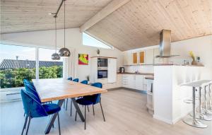 cocina con mesa de madera y sillas azules en Awesome Home In Sby With Kitchen, en Nordost