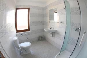 a white bathroom with a toilet and a sink at Grand hotel/pension in Sládkovičovo +12 photos