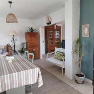 a living room with a table and a chair at Fauvette17 in Saint-Palais-sur-Mer