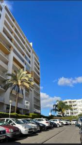 een parkeerplaats met auto's geparkeerd voor een gebouw bij Apartamento Altumar T2 in Portimão