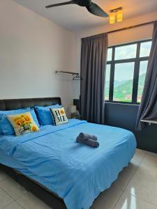 ein Schlafzimmer mit einem blauen Bett und einer blauen Decke in der Unterkunft The Sun 1 or 3BR Bayan Lepas 4 to 10 pax in Bayan Lepas