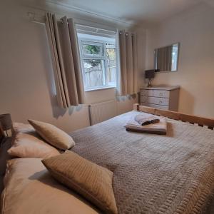 a bedroom with a bed with two pillows and a window at Private one bedroom apartment with garden and parking in Thame