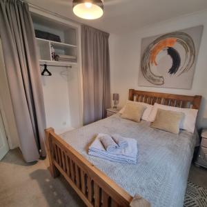 a bedroom with a large bed with towels on it at Private one bedroom apartment with garden and parking in Thame