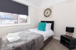 a bedroom with a large bed and a window at Spacious-Comfortable-Free Parking-Garden in Nottingham