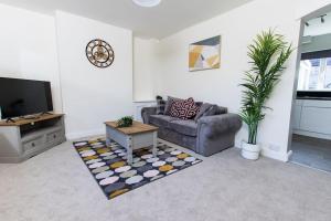 a living room with a couch and a table at Spacious-Comfortable-Free Parking-Garden in Nottingham