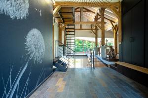 a hallway with a staircase in a building with wooden ceilings at La Ferme du Lanchet in Lamoura