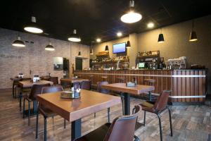 a restaurant with tables and chairs and a bar at Pensión Los Trillizos in Boiro