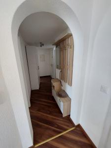 a hallway with an archway in a room with wood floors at Alpin Relax in Saas-Almagell