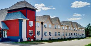 a large building with a red building at Coast Fort St John Hotel in Fort Saint John