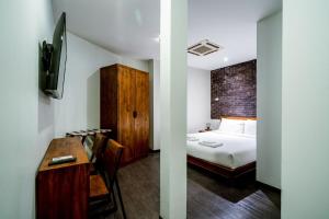 a bedroom with a bed and a desk with a desk at GO INN Sukhumvit 20 Bts Asoke-Phrom Phong in Bangkok