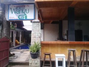 a sign for a restaurant with stools in front of it at Wahyu Gili 1 in Gili Trawangan