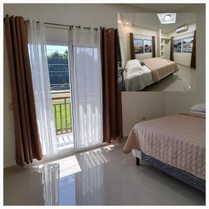 1 dormitorio con cama y ventana grande en Maho's Apartamentos en Tela