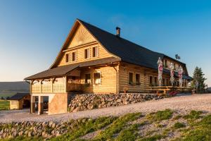 a large wooden house on a hill with american flags at Koliba Holica in Huty