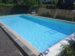 a swimming pool with blue water in a yard at Villa METICA - Aussillon/Mazamet in Aussillon