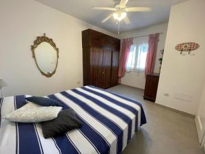 a bedroom with a blue and white bed and a mirror at Alba Chiara Sea View in Santa Teresa Gallura