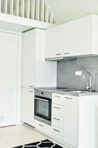 uma cozinha com armários brancos e um forno com placa de fogão em Charming little country house in central Älmhult em Älmhult