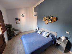 a bedroom with a blue bed and a blue wall at Il Melograno casa vacanze in Teulada