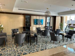 um lobby de um hotel com cadeiras e mesas em فندق مروج نجد em Jidá