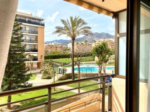 een balkon met uitzicht op een zwembad en palmbomen bij Hevres Playa Torremolinos in Torremolinos