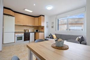 cocina y sala de estar con mesa de madera en una habitación en Encantador apartamento en El Delta del Ebro-Apartaments Iaio Kiko, en El Lligallo del Gànguil