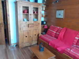 a living room with a red couch and a cabinet at Appartement exceptionnel à Valmorel in Valmorel
