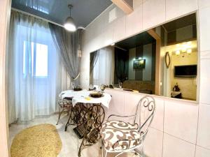 uma sala de jantar com uma mesa, cadeiras e um espelho em 1-кімн Французький шик у центрі Полтави ,Корпусний парк em Poltava