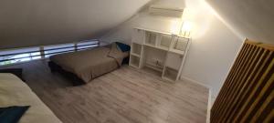 Dormitorio pequeño con cama y estante de libros en Emplacement d'exception en Filaos