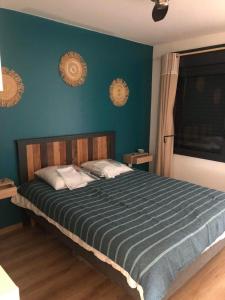 ein Schlafzimmer mit einem großen Bett mit blauer Wand in der Unterkunft L'Octan Océan in Saint-Leu