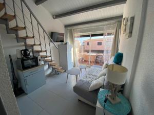 a living room with a couch and a spiral staircase at 746 Aphrodite naturiste in Leucate