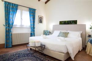 a bedroom with a large white bed with blue curtains at Il Bagattino in Ferrara